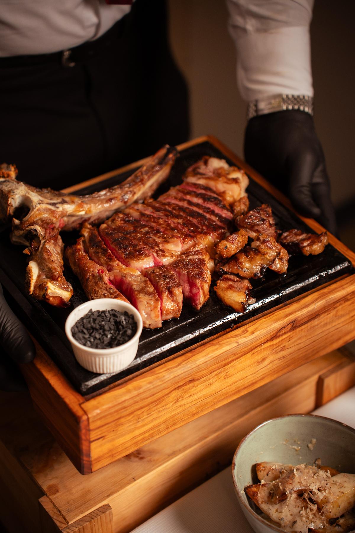 Bistecca alla fiorentina tagliata e servita sulla pietra calda